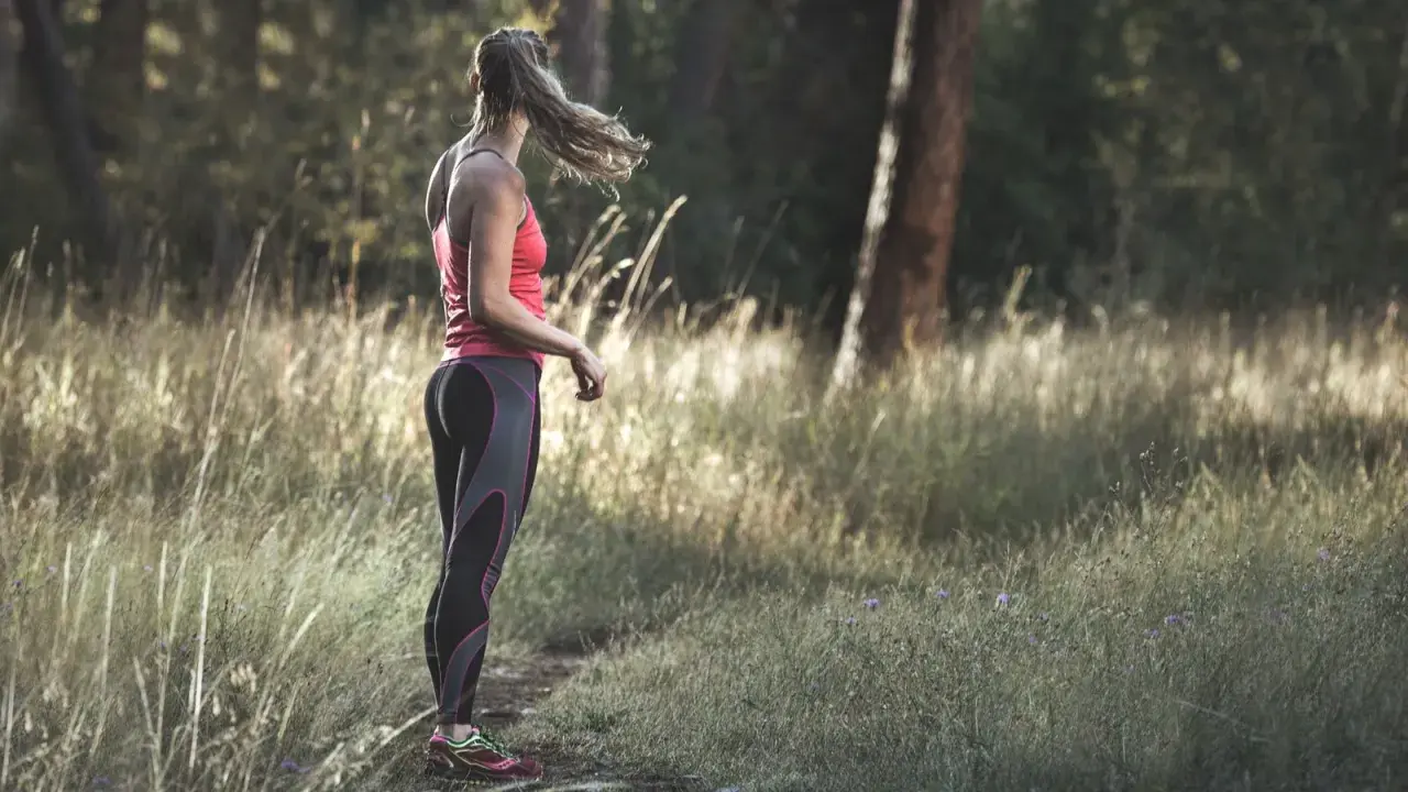 Frau in Sportkleidung steht im Wald. Tolle Jogging-Tipps für Anfänger und Fortgeschrittene.