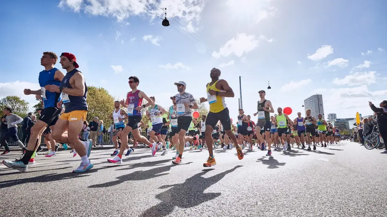 Läufer in einem Marathon, die ihr Lungenvolumen trainieren. Die Sonne scheint, der Himmel ist blau mit Wolken.