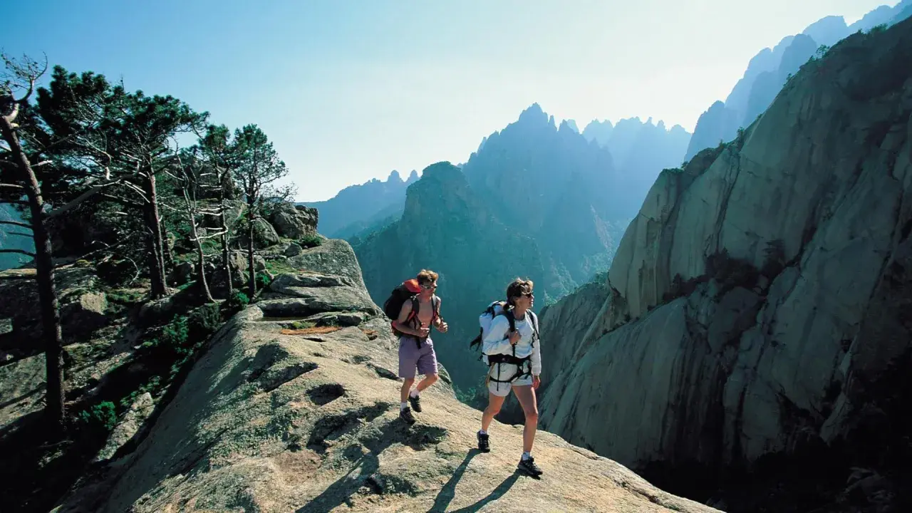 Zwei Wanderer auf dem korsika weitwanderweg genießen die atemberaubende Berglandschaft.