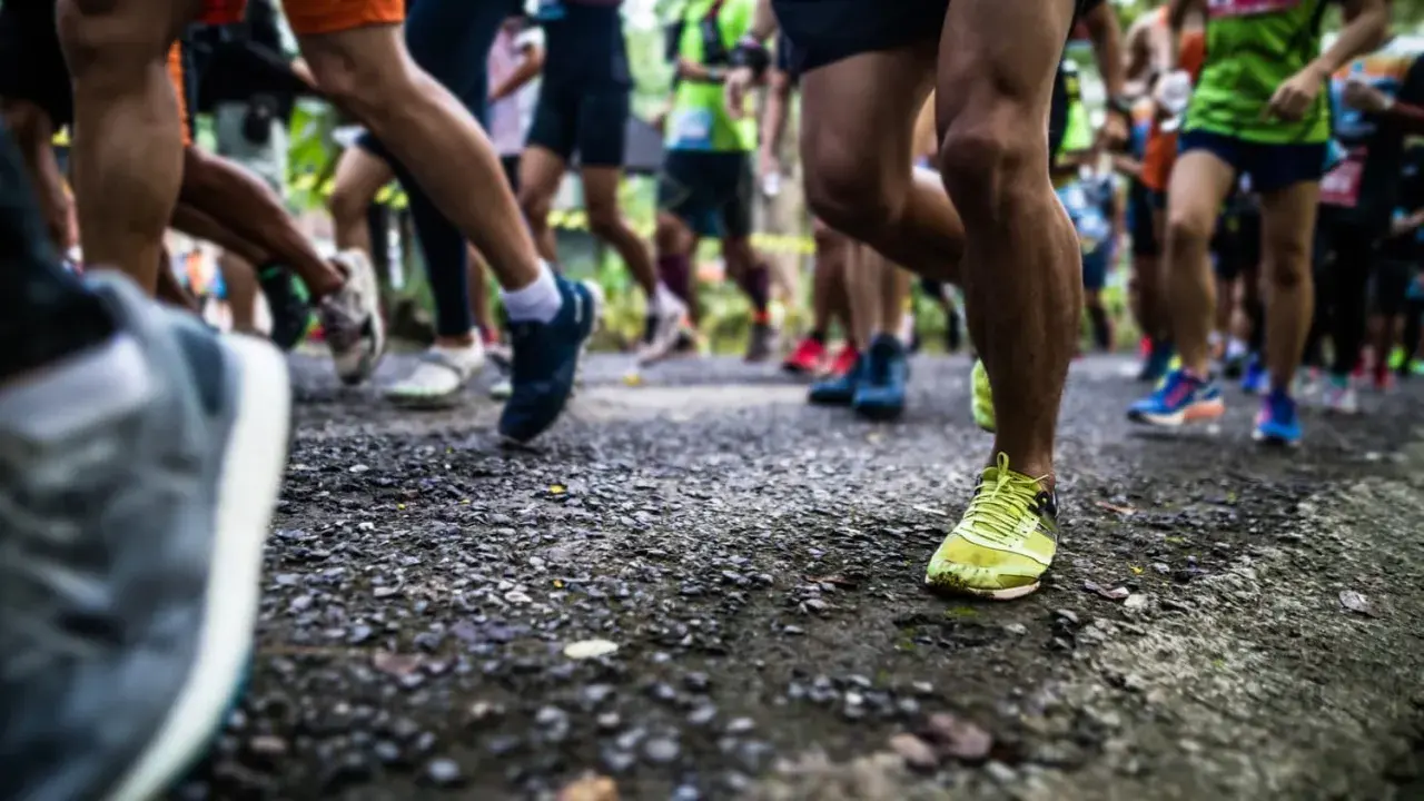 Läufer auf einer Strecke, bereit für die Halbmarathon Distanz. Beine in Bewegung, die Ziellinie im Blick.