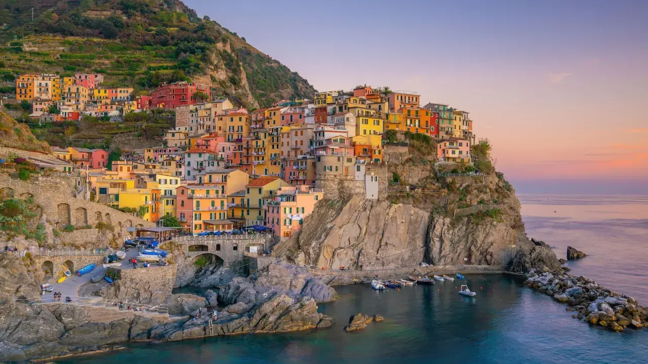 Bunte Häuser klammern sich an einen Felsen über dem Meer. Ein perfekter Ort für **La Spezia Wandern** und unvergessliche Ausblicke.