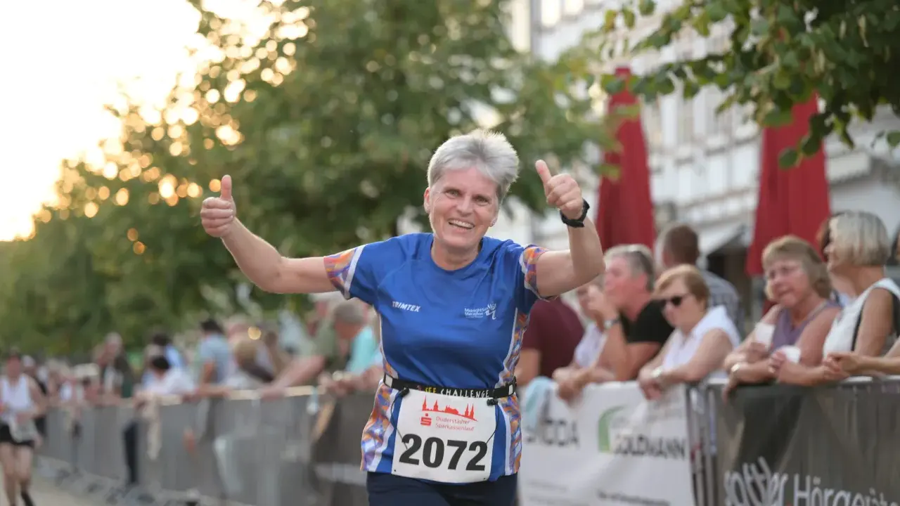 Läuferin mit Startnummer 2072 gibt beim Sparkassenlauf Aurich Daumen hoch.
