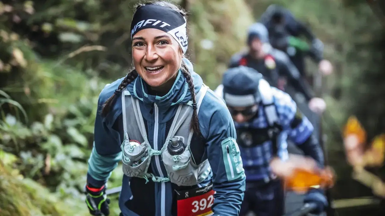 Lächelnde Läuferin beim Mountainman Nesselwang Trailrun. Sie trägt Sportkleidung und hat Zöpfe.