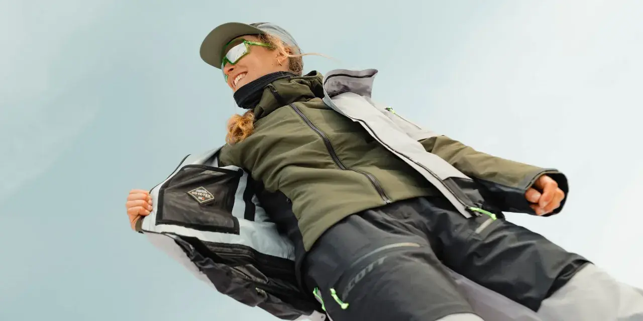 Frauenjacke mit Gore-Tex-Logo, die zeigt, was ein Midlayer ist: isolierend und atmungsaktiv für Outdoor-Abenteuer.