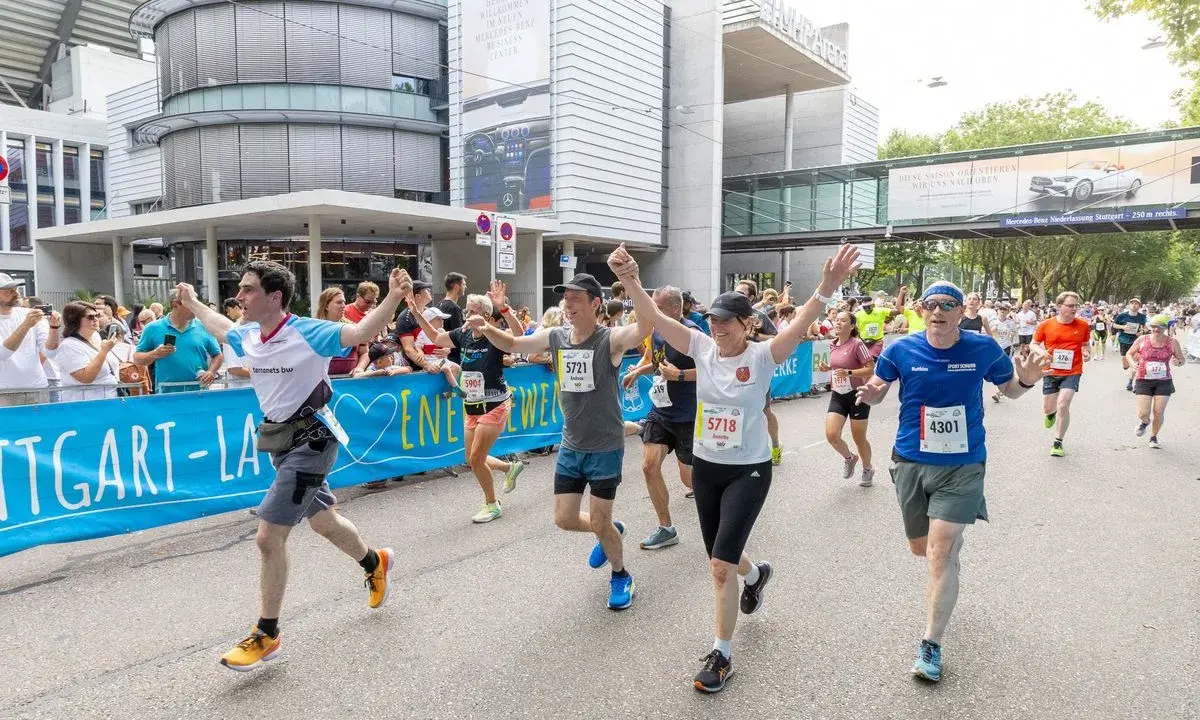 Läufer jubeln beim Marathon Stuttgart, überqueren die Ziellinie.