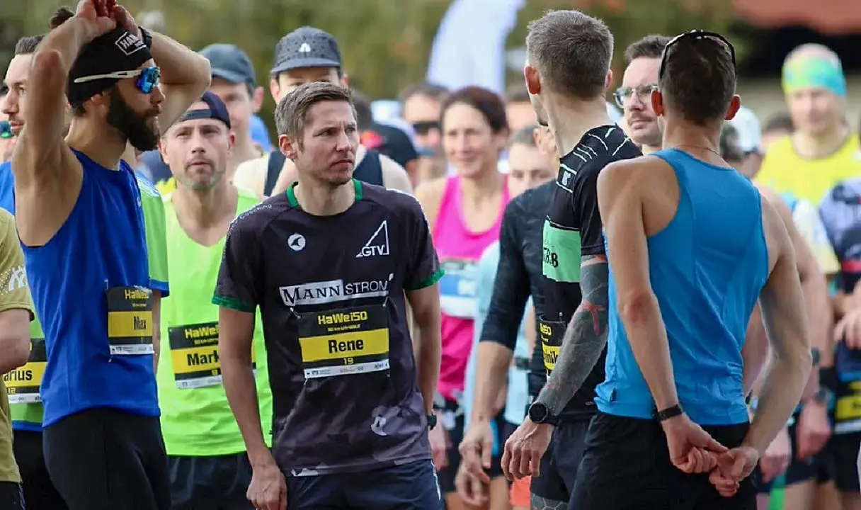 Läufer warten am Start eines Ultramarathons in Deutschland. Rene, Max und Mark sind bereit.