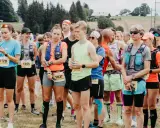 Läufer stehen bereit für den Lauf "3 Kings 3 Hills". Die Teilnehmenden tragen Startnummern und Laufbekleidung.
