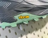 Detailaufnahme einer grünen Vibram Sohle mit gelbem Logo. Mögliche Nachteile: Abnutzung des Profils bei starker Beanspruchung.