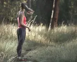 Frau in Sportkleidung steht im Wald. Tolle Jogging-Tipps für Anfänger und Fortgeschrittene.