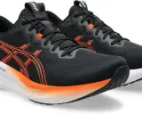 Schwarze Laufschuhe Asics Gel Pulse 16 mit orangefarbenen Akzenten und weißer Sohle.