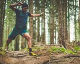 Mann im Sprung beim trailrunning training im Wald.