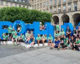 Gruppe feiert Erfolg beim urban run Bochum vor riesiger blauer Schrift.