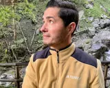 Mann in gelber Fleecejacke mit schwarzem Kragen und Schulterpartien, die zeigt, welche Fleecejacke wirklich warm ist.
