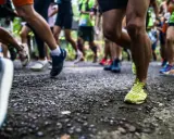 Läufer auf einer Strecke, bereit für die Halbmarathon Distanz. Beine in Bewegung, die Ziellinie im Blick.