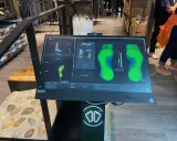 Bildschirm zeigt eine Laufschuh Analyse mit Fußabdrücken und Druckpunkten. Die Software "Smartfit" hilft bei der Auswahl des passenden Schuhs.