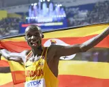 Läufer mit ugandischer Flagge, jubelt nach einem 5km-Weltrekord.