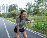 Läuferin prüft ihren Puls beim Joggen. Ihr Herz schlägt bei 180 Schlägen pro Minute. Sie ist eine Frau, die fit ist.