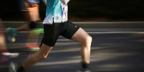 Läufer mit schweren Beinen beim Joggen, die durch die Bewegung verschwommen sind.