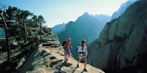 Zwei Wanderer auf dem korsika weitwanderweg genießen die atemberaubende Berglandschaft.