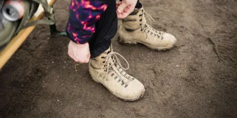 Vorbereitung für das Schneeschuhwandern: Schnüren der robusten Schuhe.