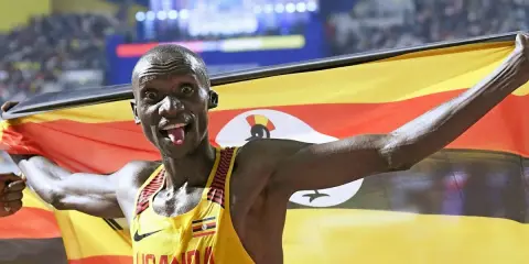 Läufer mit ugandischer Flagge, jubelt nach einem 5km-Weltrekord.