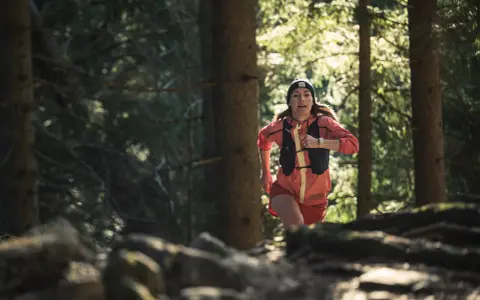 Frau beim Trailrunning im Wald, bereit für die nächsten trailrunning termine.