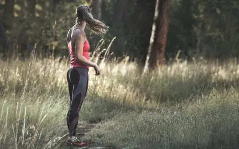 Frau in Sportkleidung steht im Wald. Tolle Jogging-Tipps für Anfänger und Fortgeschrittene.