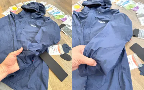 Blaue Regenjacke reparieren: Ein Loch im Ärmel wird mit einem Reparaturflicken aus dem Set ausgebessert.