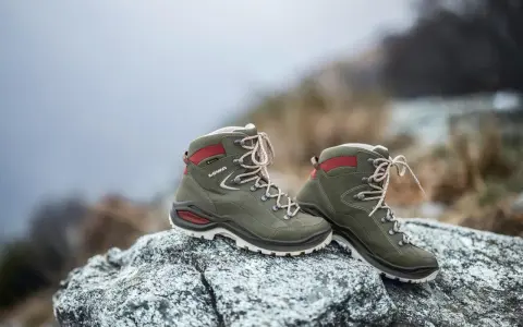 Grüne Lowa Renegade Wanderschuhe auf Felsen, bereit für den Test im Gelände.