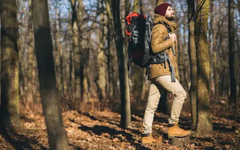 Mann mit Rucksack im Wald. Ob **trekking** oder **wandern**, die Natur ruft!