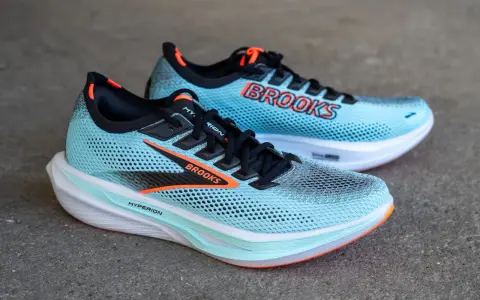 Zwei hellblaue Laufschuhe, Brooks Hyperion 3, mit orangefarbenen Akzenten und dem Brooks-Logo.