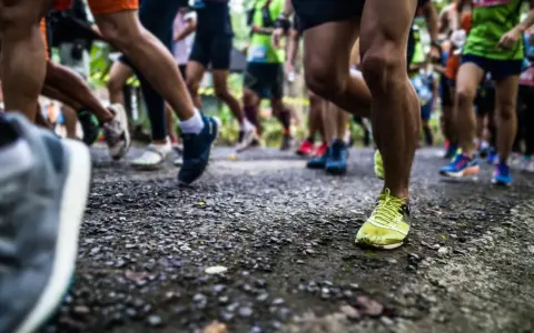 Läufer auf einer Strecke, bereit für die Halbmarathon Distanz. Beine in Bewegung, die Ziellinie im Blick.