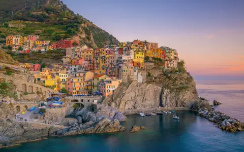 Bunte Häuser klammern sich an einen Felsen über dem Meer. Ein perfekter Ort für **La Spezia Wandern** und unvergessliche Ausblicke.