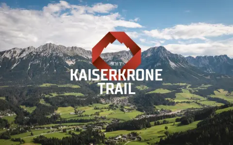 Majestätische Berge über grünen Tälern, mit dem Schriftzug "KAISERKRONE TRAIL" und einem roten Logo.