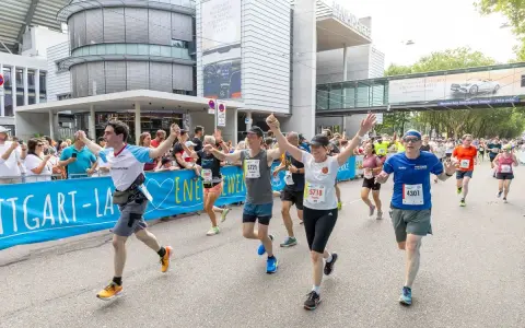 Läufer jubeln beim Marathon Stuttgart, überqueren die Ziellinie.