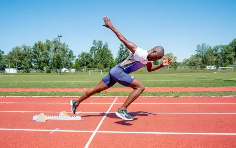 Ein Sprinter in voller Aktion, bereit für den Start. Seine explosive Kraft und Schnelligkeit sind das Ergebnis von intensivem plyometrischem Training.
