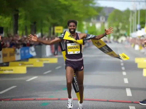 Läufer durchbricht jubelnd die Ziellinie beim Hannover Marathon. Ein Highlight im laufkalender niedersachsen.