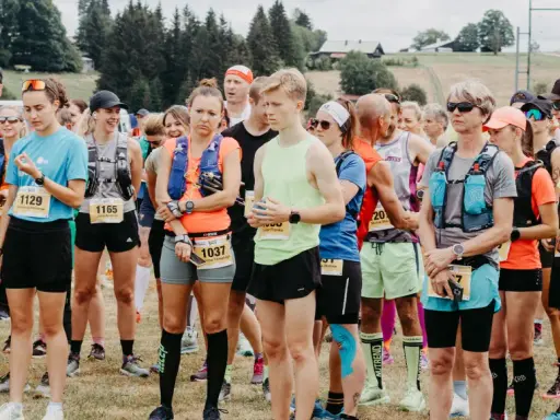 Läufer stehen bereit für den Lauf "3 Kings 3 Hills". Die Teilnehmenden tragen Startnummern und Laufbekleidung.