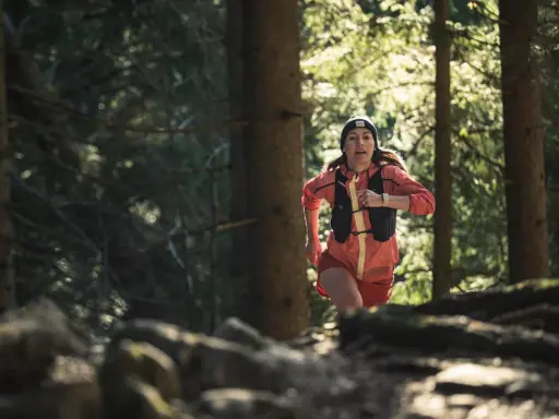 Frau beim Trailrunning im Wald, bereit für die nächsten trailrunning termine.