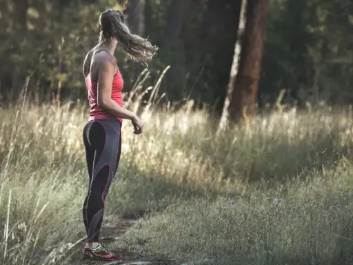 Frau in Sportkleidung steht im Wald. Tolle Jogging-Tipps für Anfänger und Fortgeschrittene.