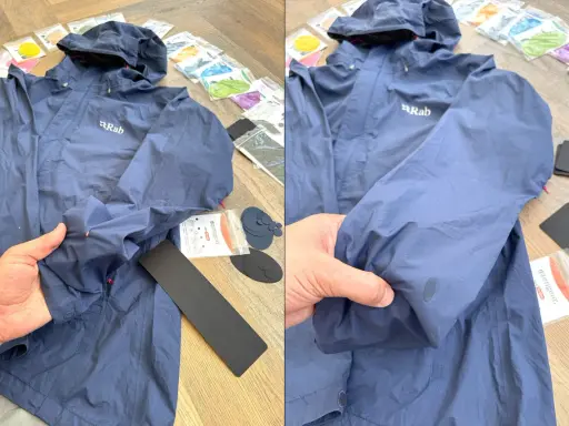 Blaue Regenjacke reparieren: Ein Loch im Ärmel wird mit einem Reparaturflicken aus dem Set ausgebessert.