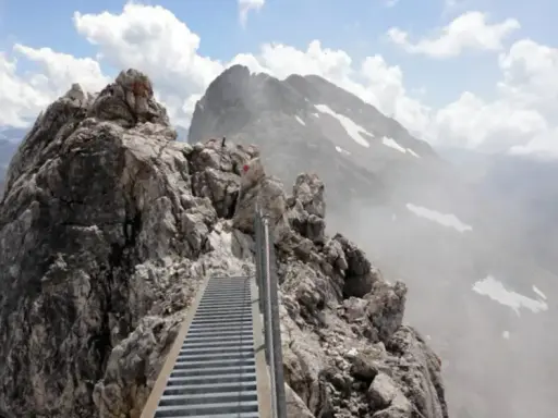 Ein steiler Metallsteg führt über felsige Gipfel. Ein Abenteuer auf dem Heilbronner Weg wandern.