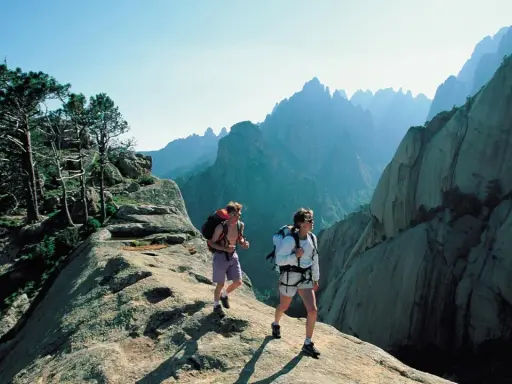 Zwei Wanderer auf dem korsika weitwanderweg genießen die atemberaubende Berglandschaft.