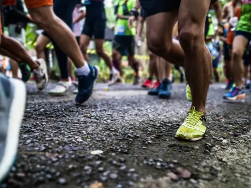 Läufer auf einer Strecke, bereit für die Halbmarathon Distanz. Beine in Bewegung, die Ziellinie im Blick.