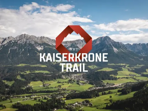 Majestätische Berge über grünen Tälern, mit dem Schriftzug "KAISERKRONE TRAIL" und einem roten Logo.