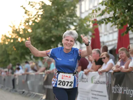 Läuferin mit Startnummer 2072 gibt beim Sparkassenlauf Aurich Daumen hoch.