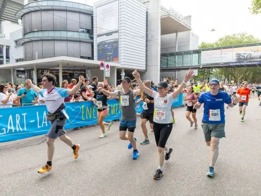 Läufer jubeln beim Marathon Stuttgart, überqueren die Ziellinie.