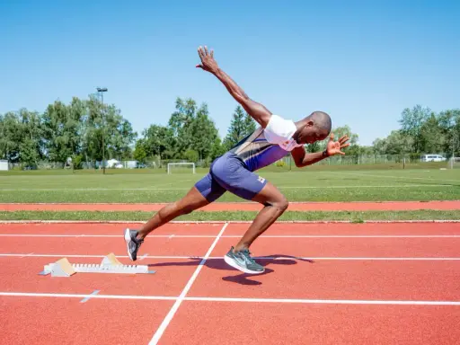 Ein Sprinter in voller Aktion, bereit für den Start. Seine explosive Kraft und Schnelligkeit sind das Ergebnis von intensivem plyometrischem Training.