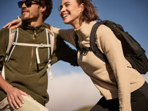 Glückliches Paar in warmen Fleece-Pullovern und Rucksäcken genießt die Natur. Fleece ist weich und isolierend.