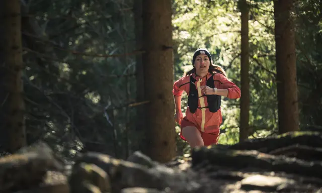 Frau beim Trailrunning im Wald, bereit für die nächsten trailrunning termine.